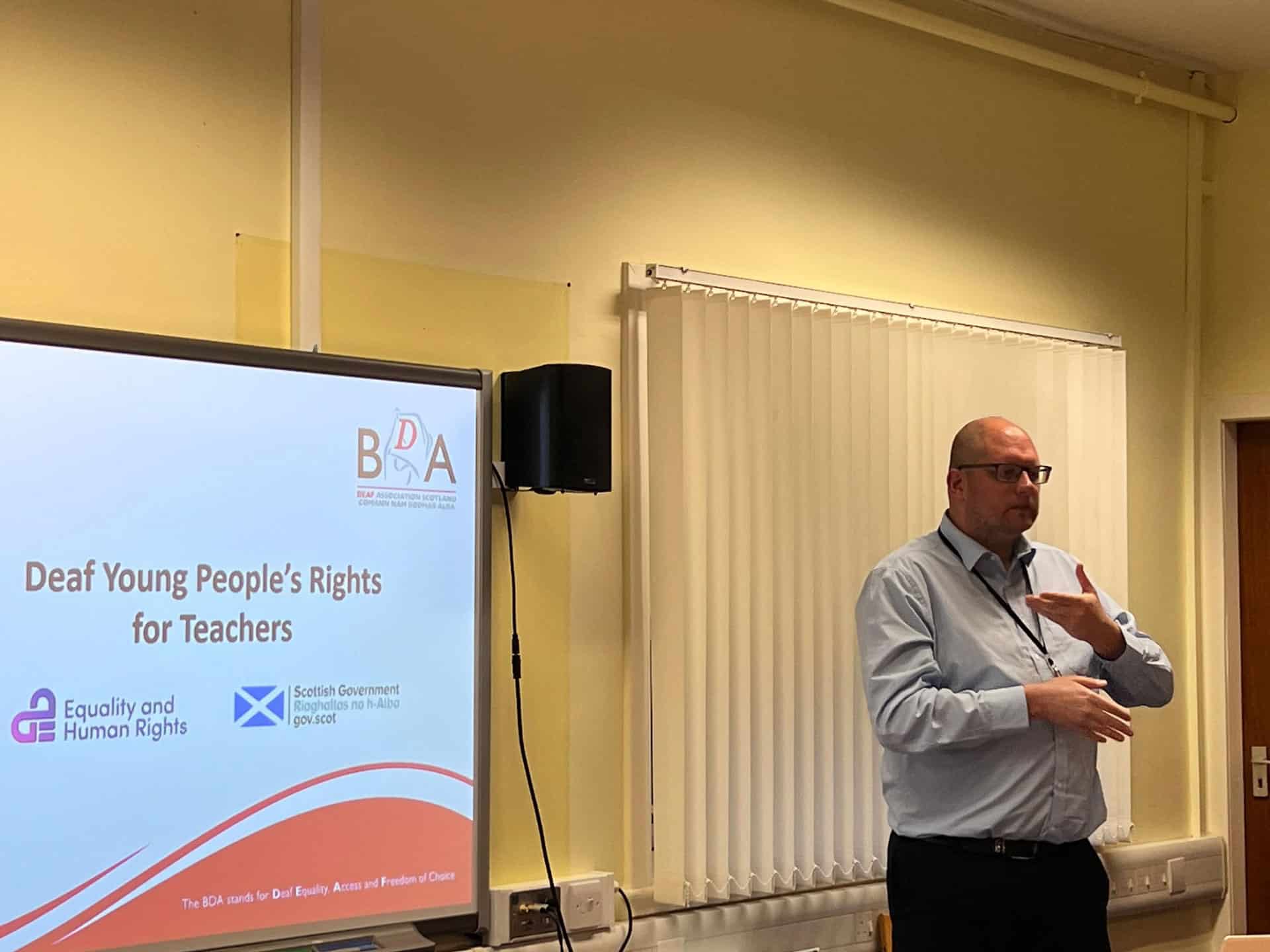Speaker at BSL Act 2015 event discussing deaf rights in Scotland.