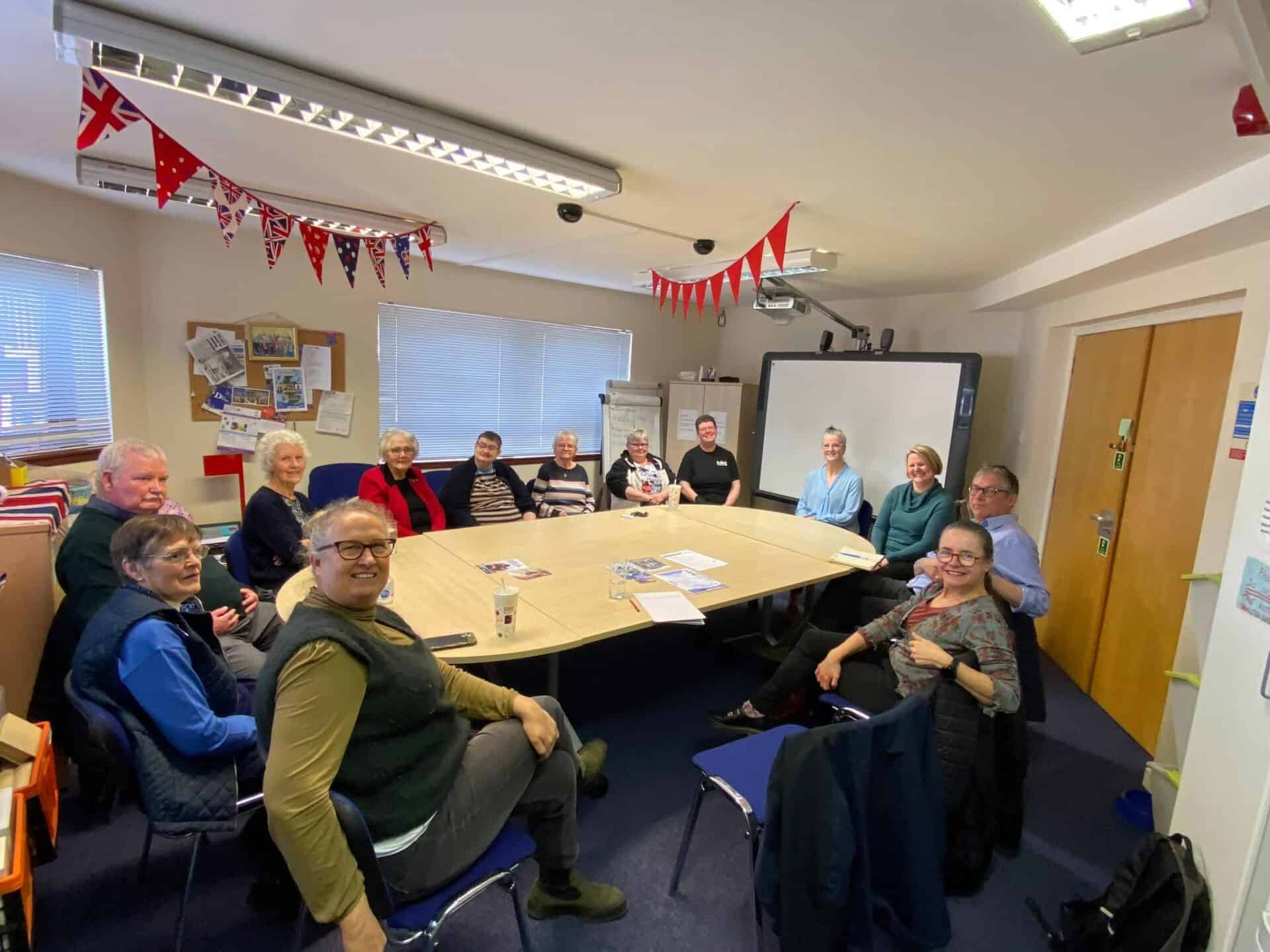 Group of people in a meeting room celebrating BSL (Scotland) Act 2015.