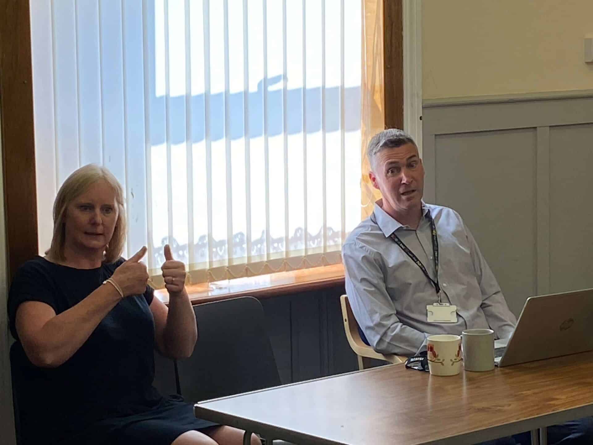 Two people in a meeting discussing the BSL Scotland Act 2015.