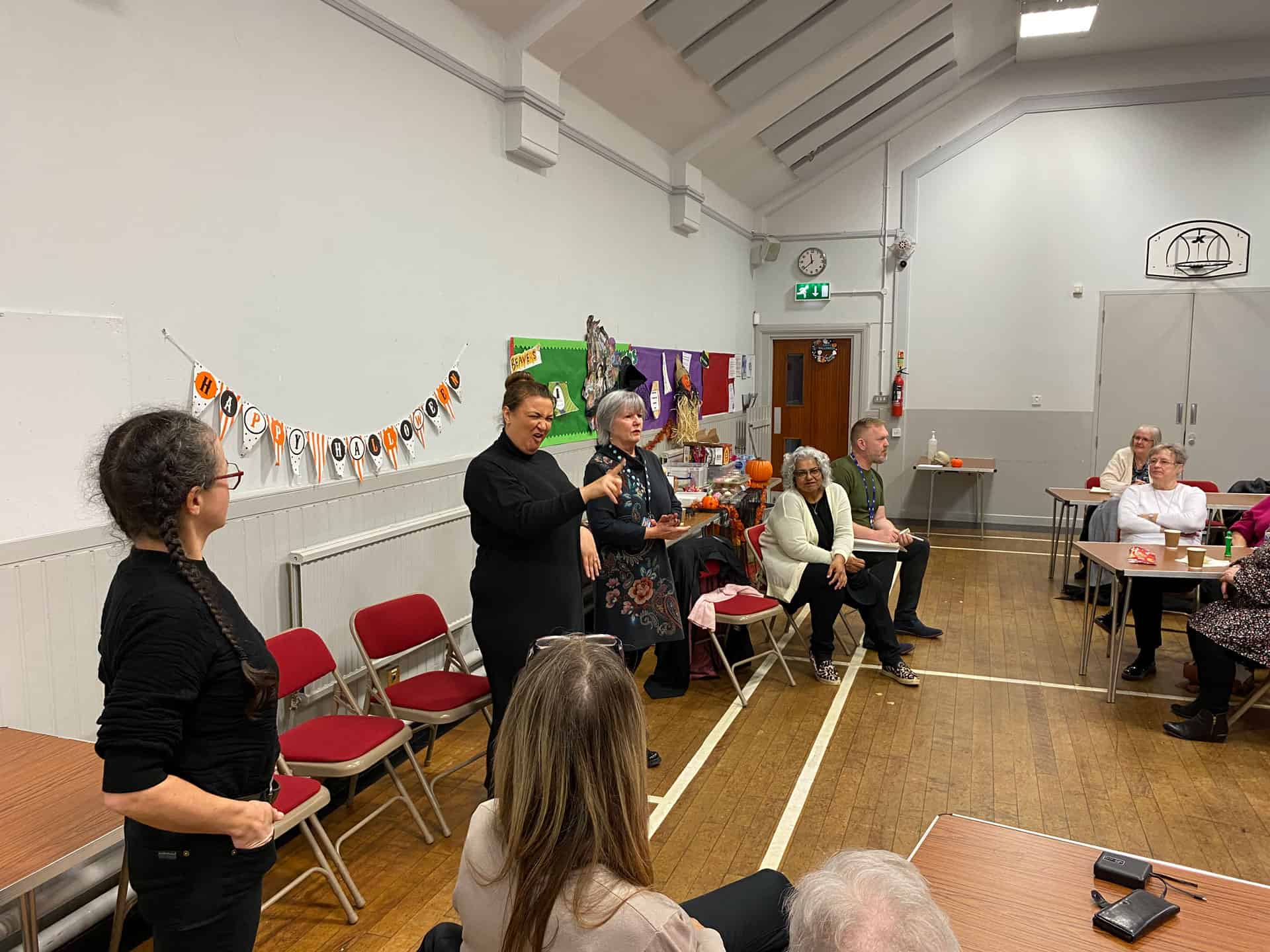 People gathered in a community hall discussing BSL (Scotland) Act 2015.