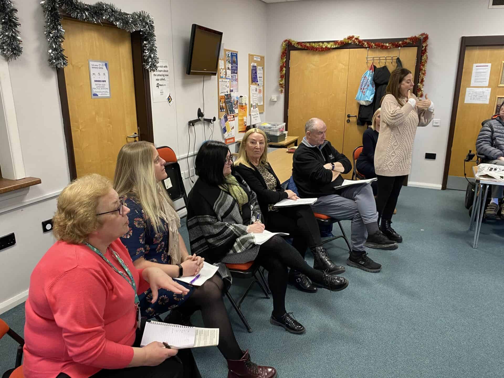 Deaf community members discussing BSL Act 2015 in a meeting room.