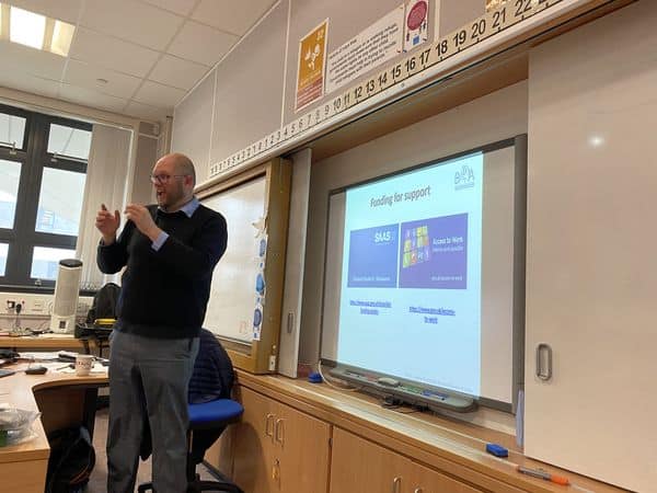 Speaker presenting about the BSL (Scotland) Act 2015 in a classroom.