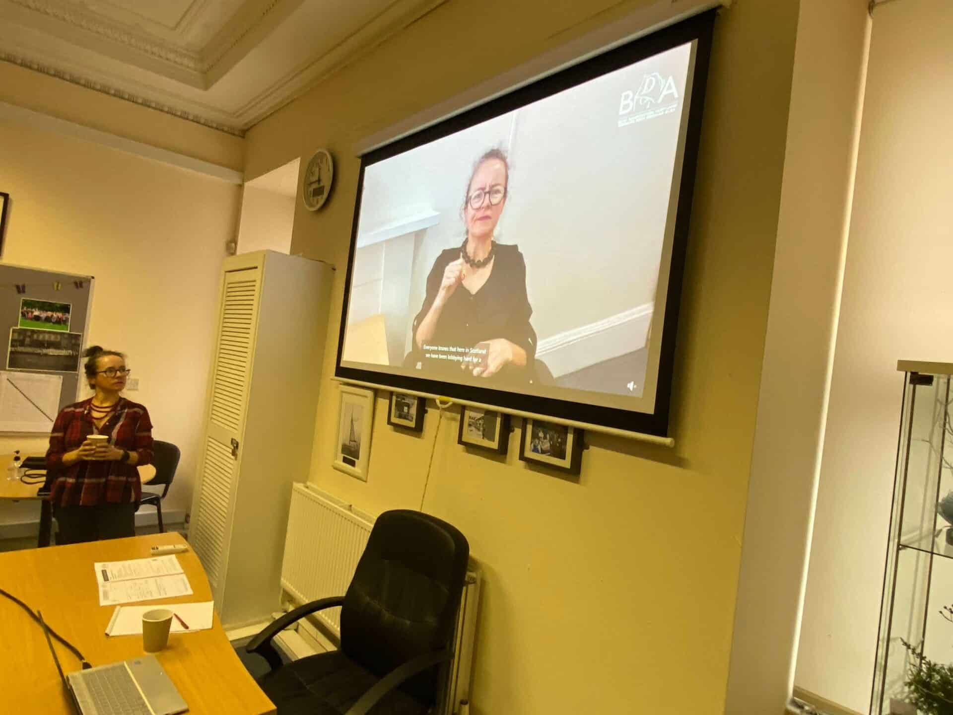 Woman signing in British Sign Language during a presentation on the BSL Act 2015.