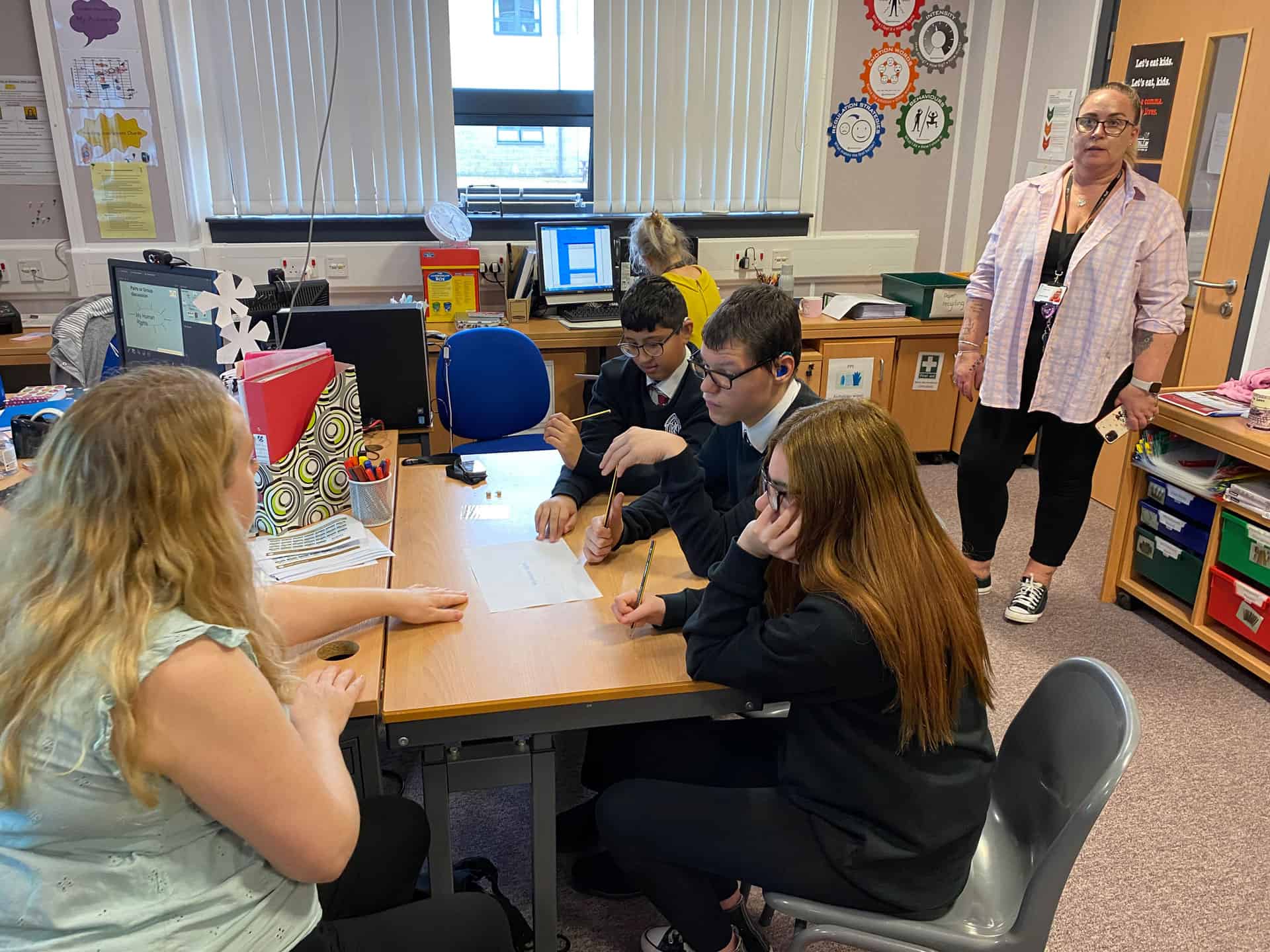 Students practicing sign language in a classroom setting in Scotland.